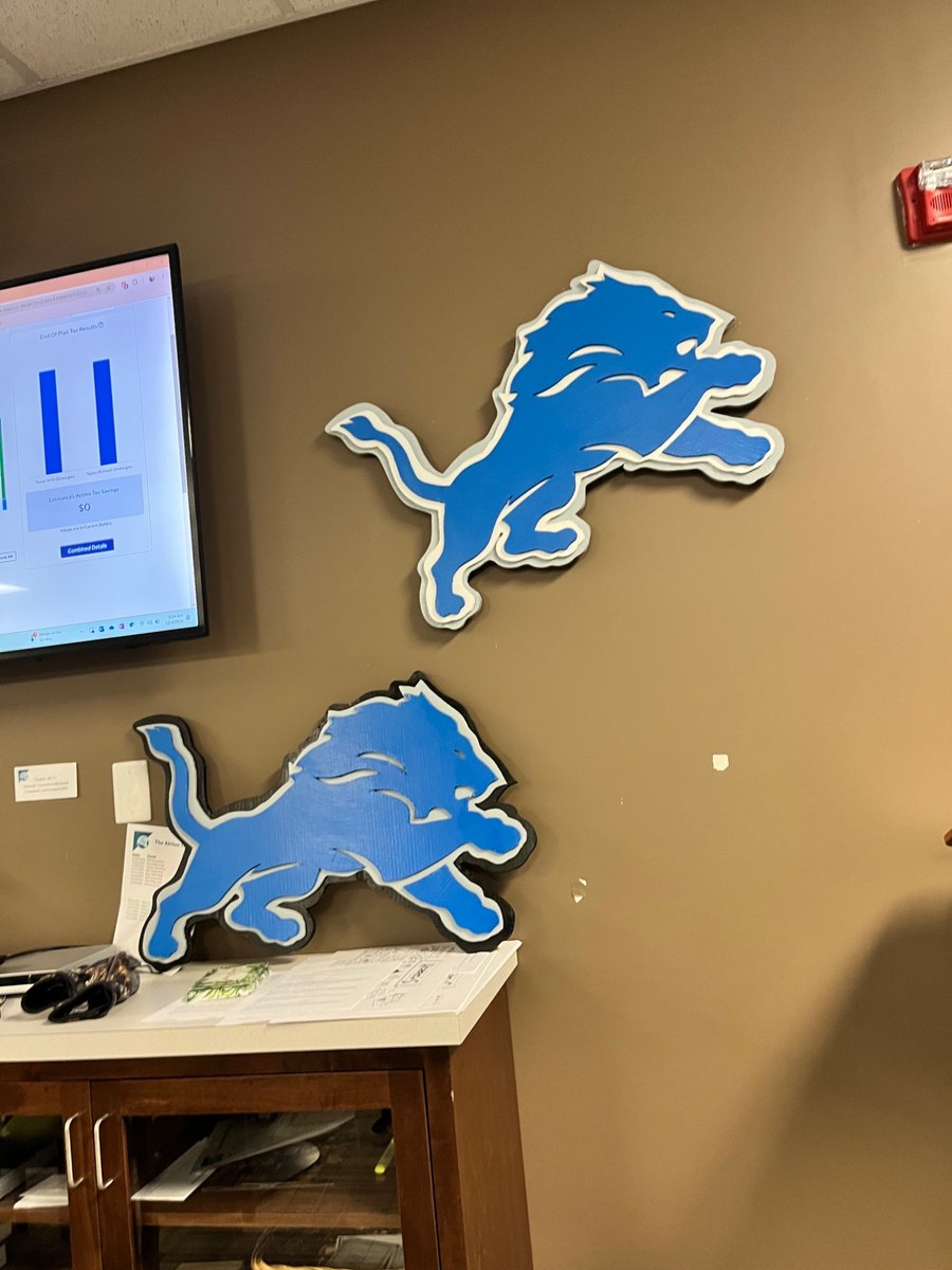 Two custom Detroit Lions logo cutouts on an office wall