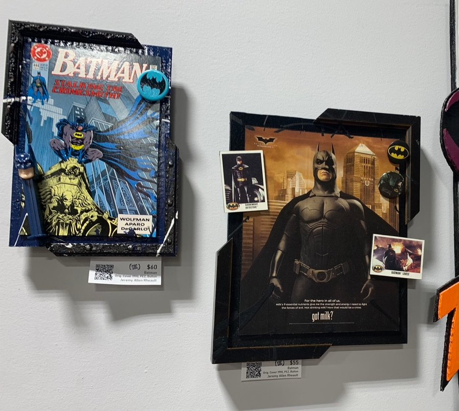 Hand-embellished Batman Stalking the Crimesmith comic with a PEZ dispenser, and a Batman Begins got milk poster piece with trading cards and buttons, on a shop wall