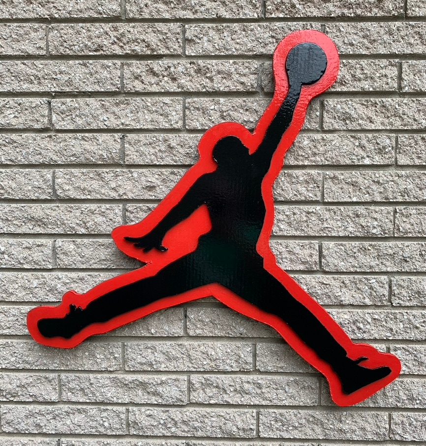 Custom Jumpman basketball logo cutout in black and red on a brick wall