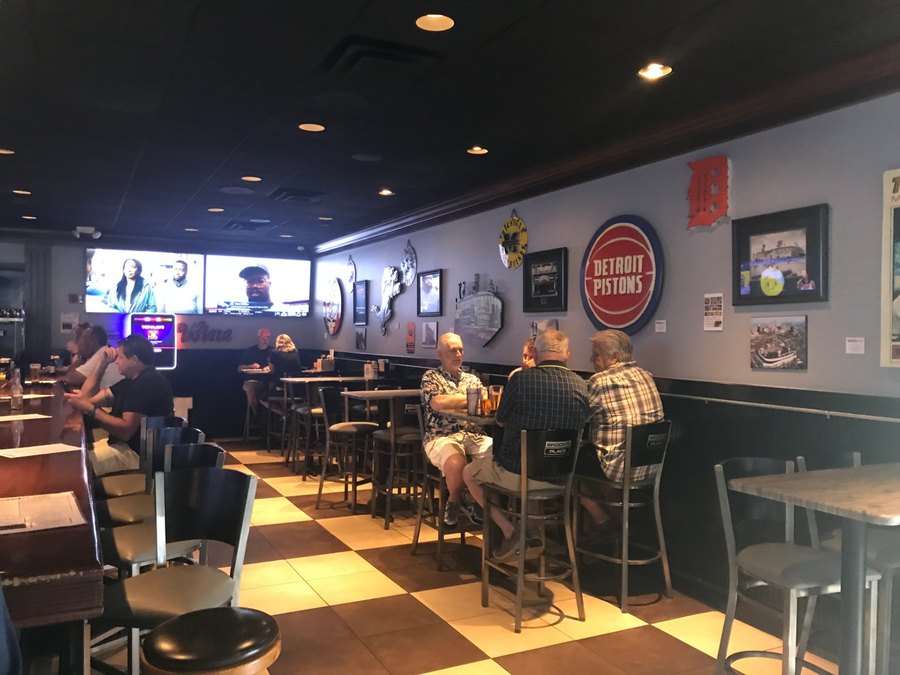 Custom Detroit Pistons logo cutout on a sports bar wall beside a Tigers D