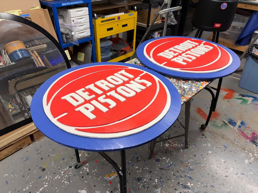 Two custom Detroit Pistons logo cutouts in the Art Jar workshop
