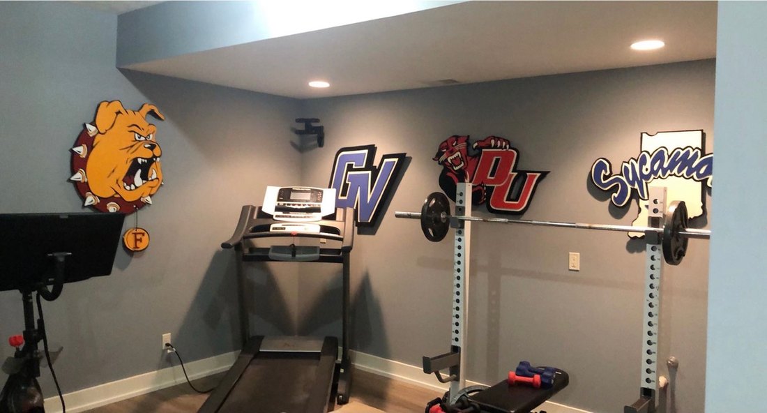 Custom Ferris State Bulldog, Grand Valley GV, Davenport DU panther and Indiana State Sycamores cutouts on the walls of a home gym