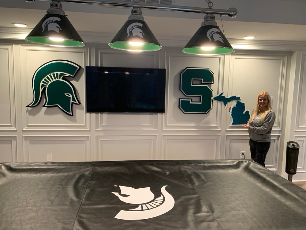 Custom Michigan State Spartan helmet, block S and Michigan state cutouts on a game room wall above a pool table