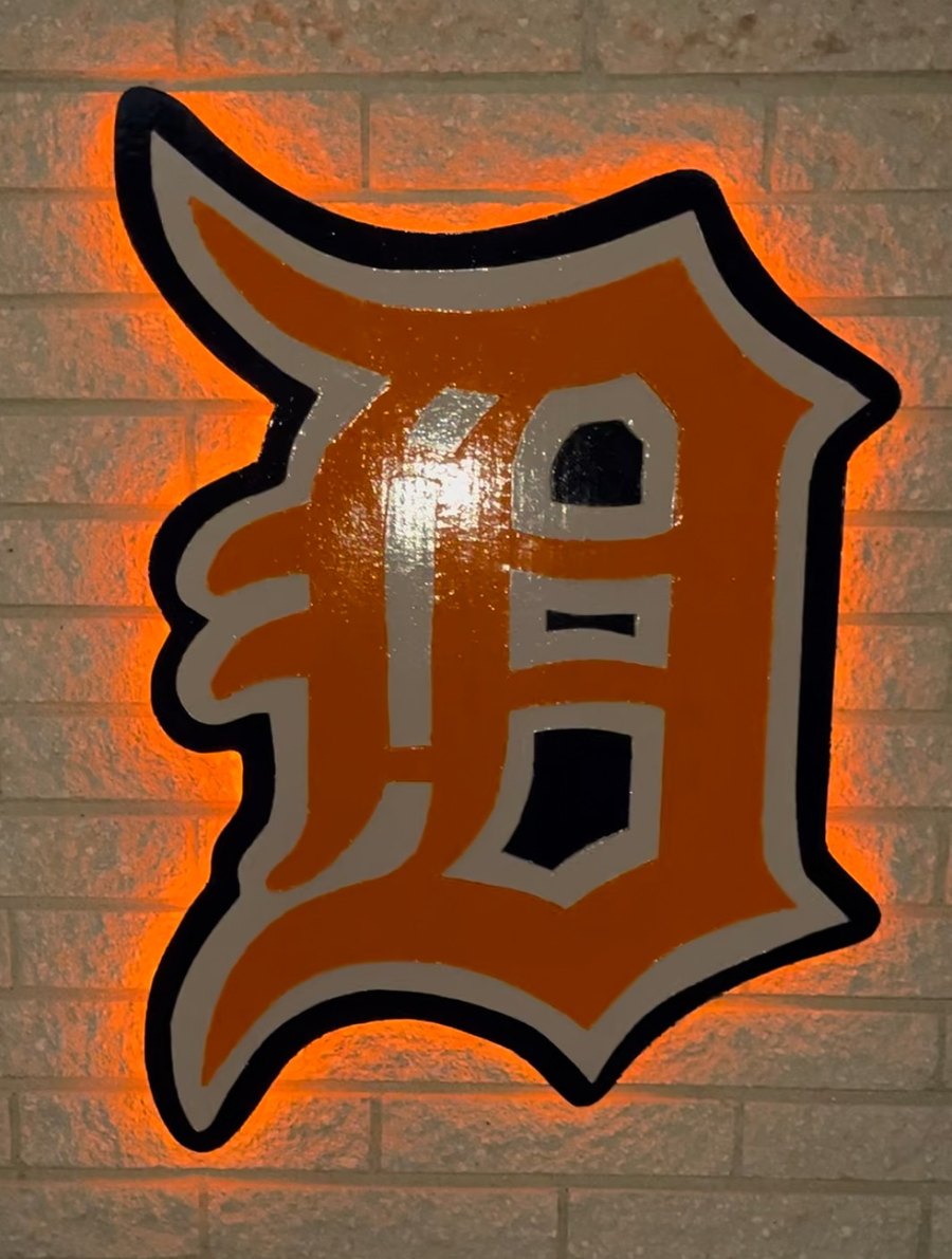 Custom orange Detroit Tigers Old English D cutout with orange LED glow on brick wall