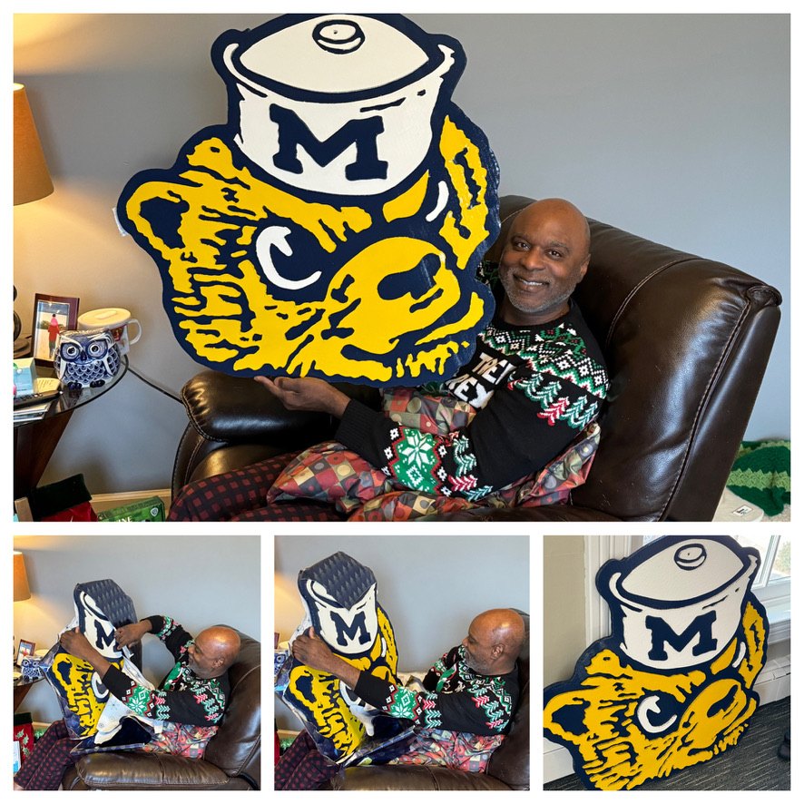 A customer opening and holding the custom Classic Wolverine mascot cutout as a Christmas gift, collage of the unwrapping and the finished piece