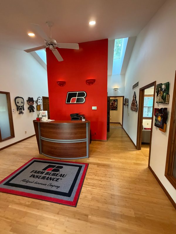 Reception desk and red feature wall with Farm Bureau logo and art displayed