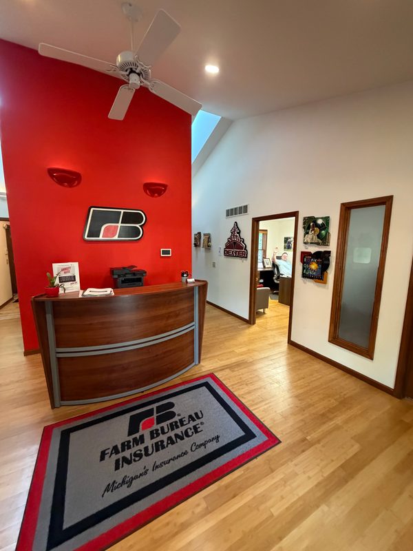 Lobby view with the red wall, Farm Bureau rug and art along the hallway