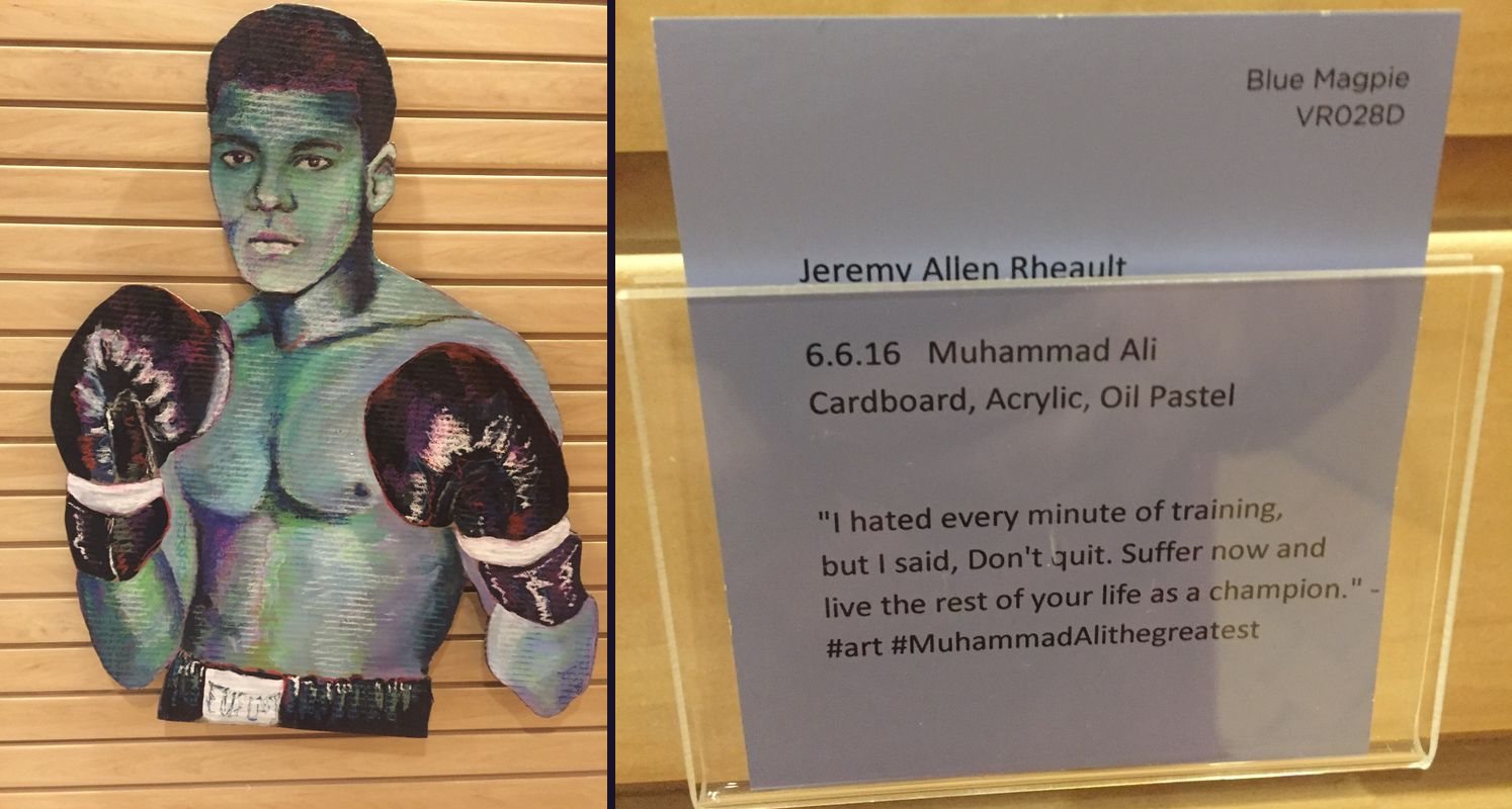 Painted cardboard portrait of Muhammad Ali in boxing gloves next to its periwinkle gallery card