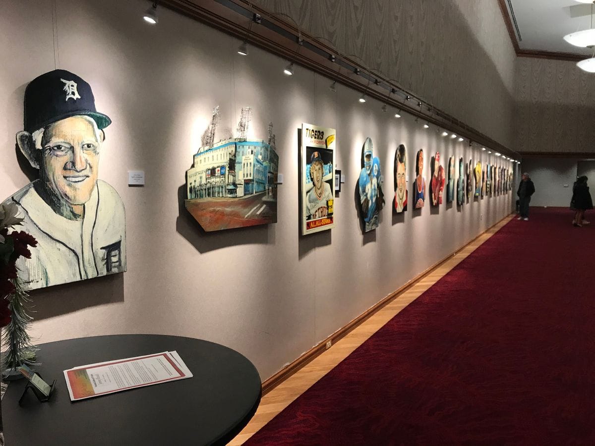 Gallery hallway with portraits along the wall and the exhibit table in front