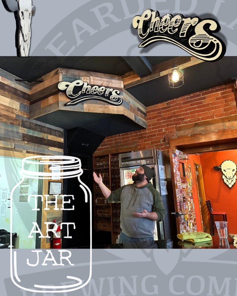 Promotion image: a man pointing up at the Cheers sign over the bar at Bearded Lamb Brewing Co., with a close-up of the Cheers sign, the sheep logo on the orange door, and The Art Jar logo