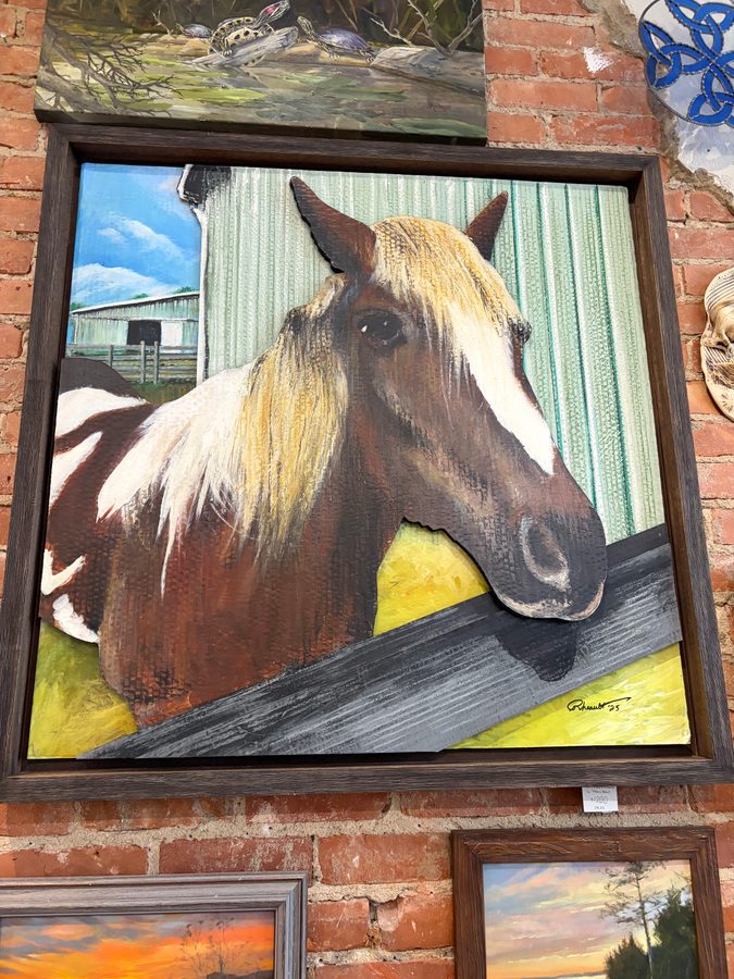 Finn, a chestnut horse with a pale mane leaning over a fence