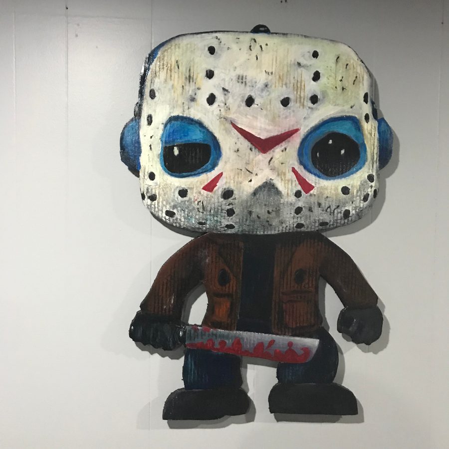 The hand-painted Jason Voorhees Funko-style cutout with his hockey mask and machete on a white wall