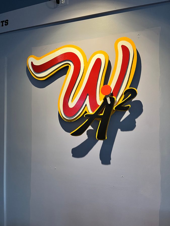 Close view of the layered red, white and yellow W logo with its black A2