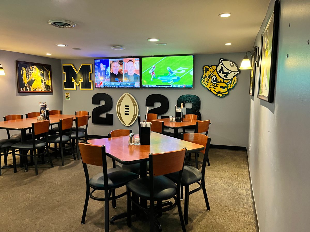 Upper dining room with the 2023 National Championship logo, a Michigan M and a wolverine head on the wall