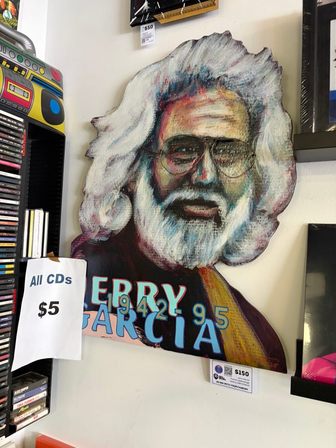 Hand-cut Jerry Garcia portrait piece hanging next to a CD rack at Vinyl People Records
