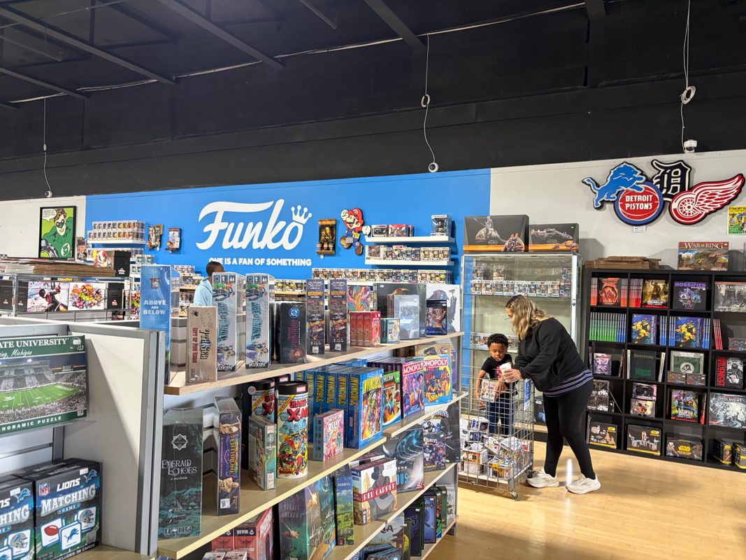 A child looking at the Funko Pops with a parent inside State of Comics