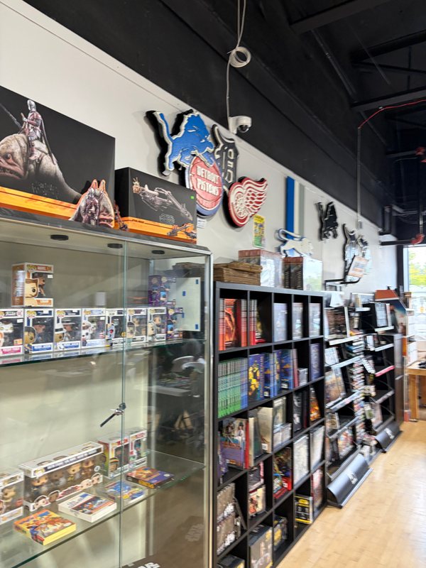 Lions, Tigers, Pistons and Red Wings logo cutouts above the display cases at State of Comics